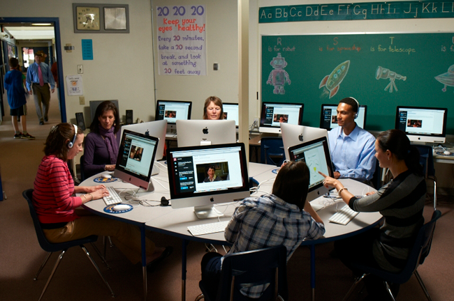 Teachers in a computer lab receiving online support.